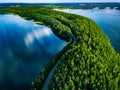 Aerial view of road with cars between green forest and blue lake water in Finland Royalty Free Stock Photo