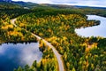 Aerial view of road and colorful autumn  forest with mountains and blue lakes in Finland Royalty Free Stock Photo