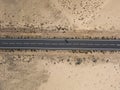 Aerial view of a road in the desert, cyclist racing on the bicycle on the black asphalt Royalty Free Stock Photo