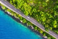 Aerial view on road in the forest. Highway throu the forest and sea coast. View from a drone. Natural landscape in summer time fro Royalty Free Stock Photo