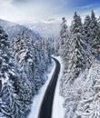 Aerial view on the road and forest in winter time. Natural winter landscape from air. Forest under snow a the winter time. Royalty Free Stock Photo