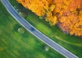 Aerial view of road through green field and forest at sunset Royalty Free Stock Photo