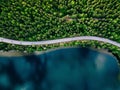 Aerial view of road between green forest and blue lake in Finland Royalty Free Stock Photo