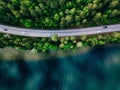 Aerial view of road between green forest and blue lake in Finland Royalty Free Stock Photo