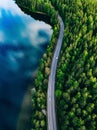 Aerial view of road between green forest and blue lake in Finland Royalty Free Stock Photo
