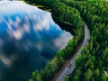 Aerial view of road between green forest and blue lake in Finland Royalty Free Stock Photo