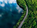 Aerial view of road between green forest and blue lake in Finland Royalty Free Stock Photo