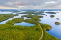 Aerial view of road between green summer forest and blue lake in Finland Royalty Free Stock Photo