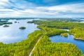 Aerial view of road between green summer forest and blue lake in Finland Royalty Free Stock Photo