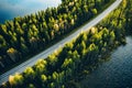 Aerial view of road between green summer forest and blue lake in Finland Royalty Free Stock Photo