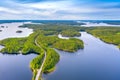 Aerial view of road between green summer forest and blue lake in Finland. Saimaa lake, Puumala. Royalty Free Stock Photo