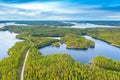 Aerial view of road between green summer forest and blue lake in Finland. Saimaa lake, Puumala. Royalty Free Stock Photo