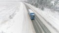 Aerial view of a road in idyllic winter landscape and a driving truck. Scene. Concept of transportation, car moving Royalty Free Stock Photo