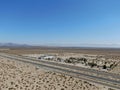 Aerial view of road in the middle of the desert under blue sky in California`s Mojave desert, near Ridgecrest. Royalty Free Stock Photo
