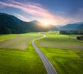 Aerial view of road in mountain valley, green meadows at sunset Royalty Free Stock Photo