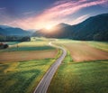 Aerial view of road in mountain valley, green meadows at sunset Royalty Free Stock Photo