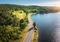 Aerial view of road near blue sea, forest at sunset in summer Royalty Free Stock Photo