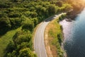 Aerial view of road near blue sea, forest at sunset in summer Royalty Free Stock Photo