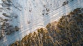 Aerial view of road passing through the snow-covered winter forest. Top view Royalty Free Stock Photo