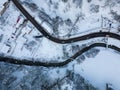 Aerial view of road and river in small town with snow covered houses.