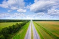 Aerial view of road on sunny summer day. Empty Highway from above. Beautiful landscape of road between green meadow and blue sky Royalty Free Stock Photo