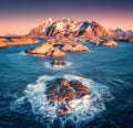 Aerial view of rocks in sea waves, Henningsvaer city, mountains