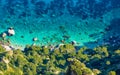 Rocky coast of Mediterranean Sea near island of Capri in Italy. Clean and clear blue water, green trees, sunny summer weather Royalty Free Stock Photo