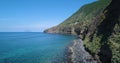 Aerial view of rocky coast in Sicily in a sunny day. Blue sea, mountains in background. Beautiful mediterranean sea