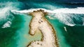 Aerial view of rocky peninsula with two cars parked in and waves crushing around Royalty Free Stock Photo