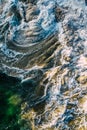 Aerial view of rolling waves and a pattern of white foam created by them crashing