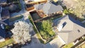 Aerial view roof shingles of suburban residential houses, backyard garden with wooden fence and front yard blossom white flower of Royalty Free Stock Photo