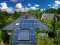 Aerial view of the roofs of houses covered with solar panels. Family houses in gardens, photovoltaic panels on the roof, Royalty Free Stock Photo