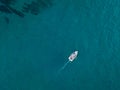 Aerial view of a rowing boat seen from above, powered by an engine. Blue sea that surrounds a boat that crosses it