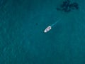 Aerial view of a rowing boat seen from above, powered by an engine. Blue sea that surrounds a boat that crosses it