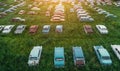 Aerial view of rows of old abandoned rusty vehicles, forgotten retro cars on green grass meadow