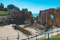 Aerial view of ruins of Greek theatre under blue bright sky in Taormina