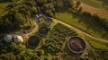 An aerial view of a rural area shows multiple biogas digesters installed on various farms. These digesters are used to