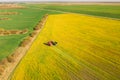 Aerial View Of Rural Landscape. Combine Harvester And Tractor Working Together In Field. Harvesting Of Oilseed In Spring Royalty Free Stock Photo