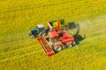 Aerial View Of Rural Landscape. Combine Harvester And Tractor Working Together In Field. Harvesting Of Oilseed In Spring Royalty Free Stock Photo