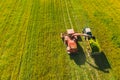 Aerial View Of Rural Landscape. Combine Harvester And Tractor Working Together In Field. Harvesting Of Oilseed In Spring Royalty Free Stock Photo