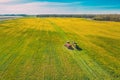 Aerial View Of Rural Landscape. Combine Harvester And Tractor Working Together In Field. Harvesting Of Oilseed In Spring Royalty Free Stock Photo