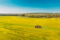 Aerial View Of Rural Landscape. Combine Harvester And Tractor Working Together In Field. Harvesting Of Oilseed In Spring Royalty Free Stock Photo