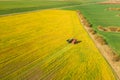 Aerial View Of Rural Landscape. Combine Harvester And Tractor Working Together In Field. Harvesting Of Oilseed In Spring Royalty Free Stock Photo