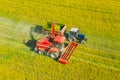 Aerial View Of Rural Landscape. Combine Harvester And Tractor Working Together In Field. Harvesting Of Oilseed In Spring Royalty Free Stock Photo