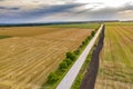 A rural landscape with a farm road, wheat fields after harvest