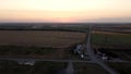 Aerial view of rural road passing through agricultural land and cultivated fields. Footage. Concept of agrarian industry