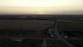 Aerial view of rural road passing through agricultural land and cultivated fields. Footage. Concept of agrarian industry