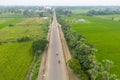 Aerial view of rural road passing through paddy fields in Guntur district, Andhra Pradesh state in India Royalty Free Stock Photo