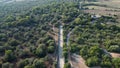 Aerial view of a rural road surrounded by Mediterranean forests at sunset Royalty Free Stock Photo