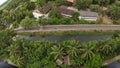 Aerial view of a rural town nestled in the countryside with a winding road lined with palm trees Royalty Free Stock Photo